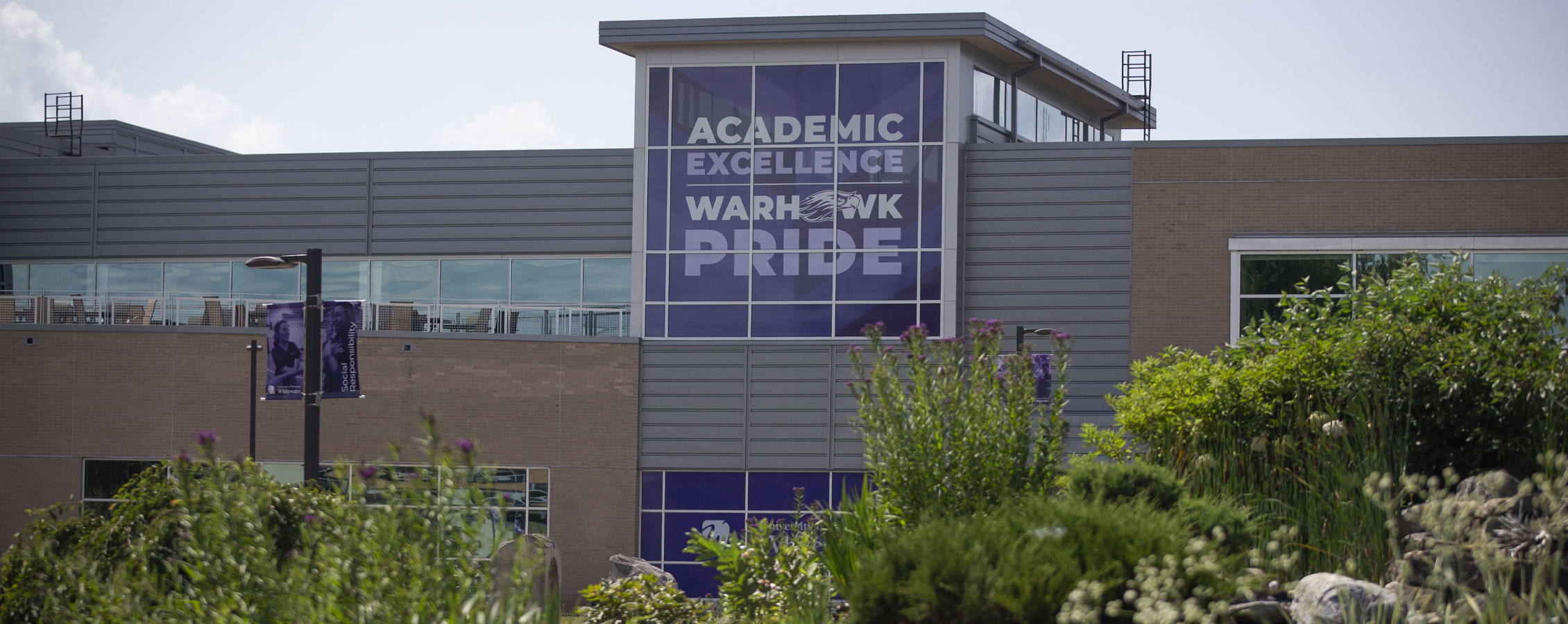 Exterior photo of the University Center with a large banner that says Academic Excellence, Warhawk Pride.