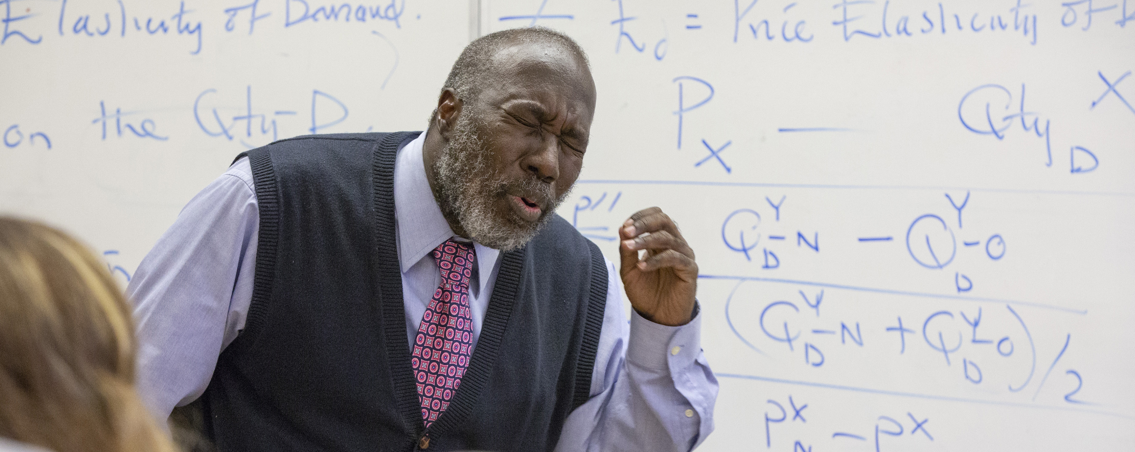 A faculty member speaks at the front of class.