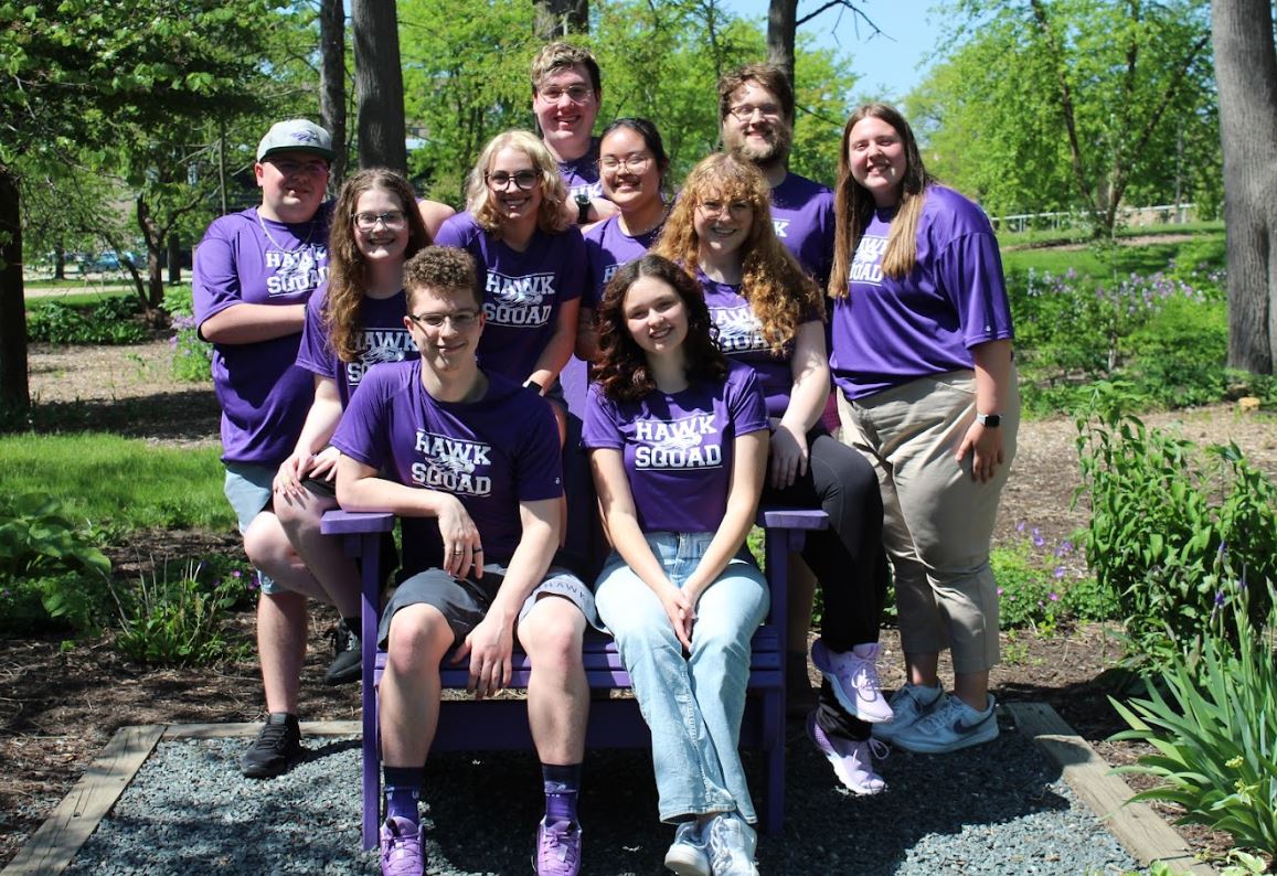 10 students in Hawk Squad purple shirts looking at camera