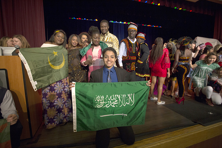 An international student holds a flag from Saudi Arabia.