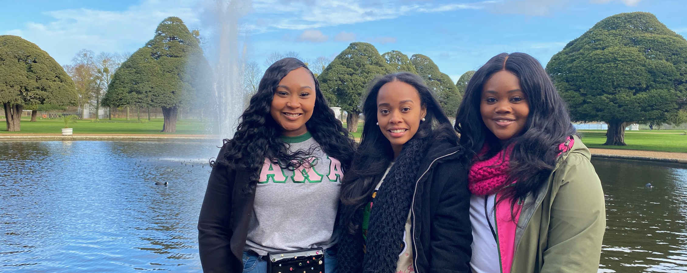 A group of people pose together in front of a fountain.