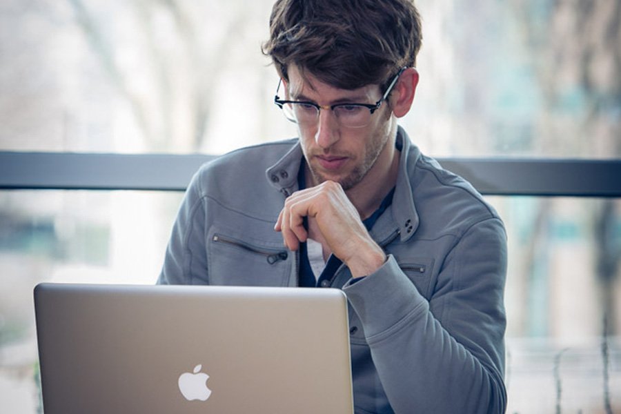 Student working on laptop off campus.