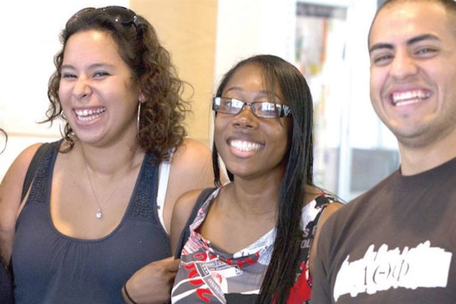 Three students smiling in class.