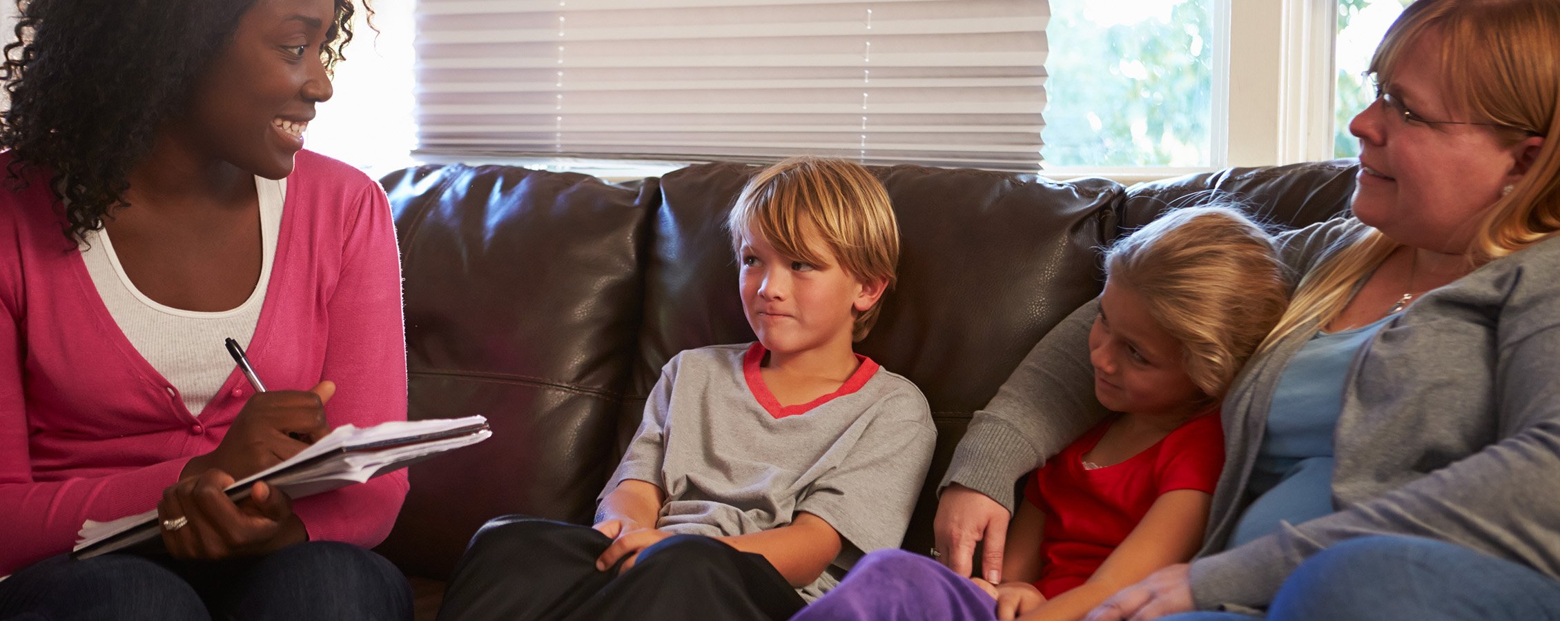 A social working is talking with a family at their home.