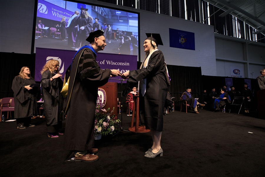 Dean Vick shakes Veena Johnnson's hand as she walk the graduation stage