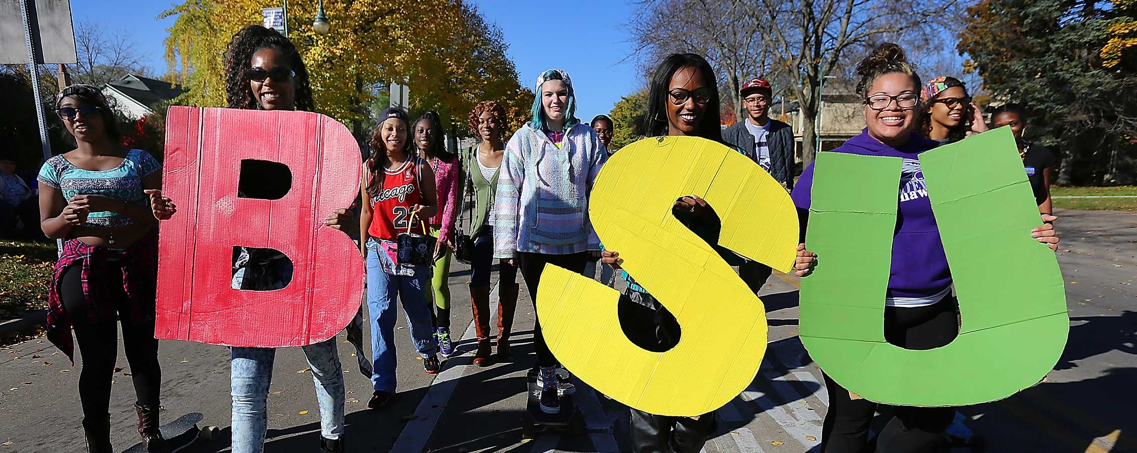 Students walk in the parade holding the letters BSU.