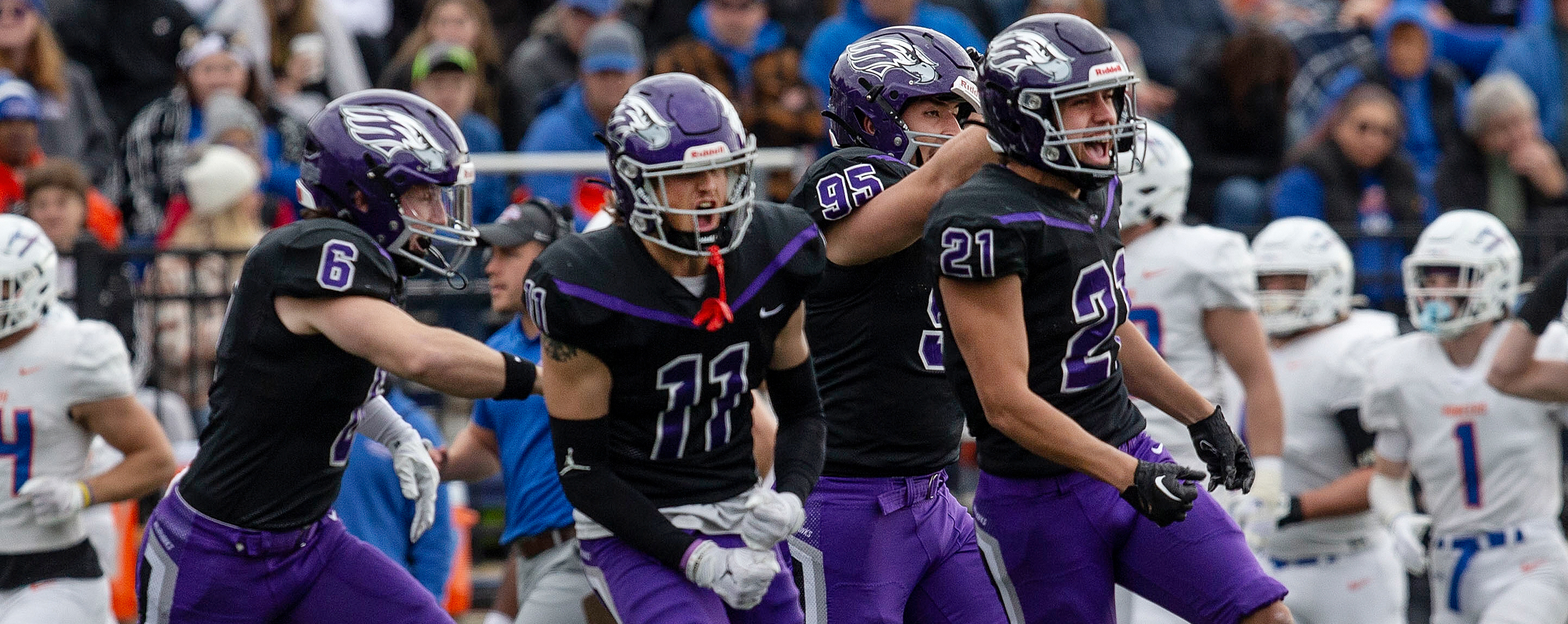 Warhawk football players celebrate on the field.