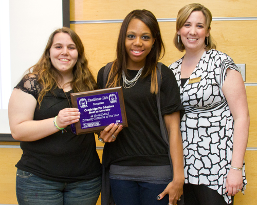 Group of students posing for a picture and holding a plaque