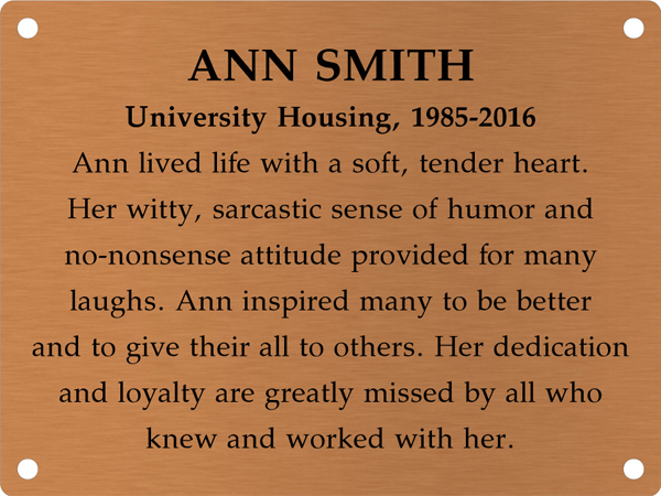 Copper memory wall plate that says Ann Smith. University Housing, 1985-2016. Ann lived life with a soft, tender heart. Her witty, sarcastic sense of humor and no-nonsense attitude provided for many laughs. Ann inspired many to be better and to give their all to others. Her dedication and loyalty are greatly missed by all who knew and worked with her.