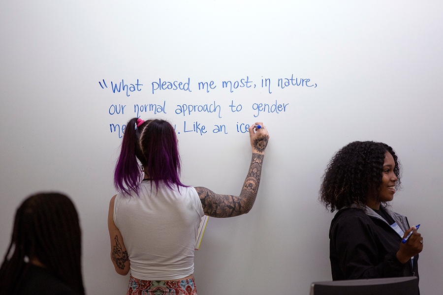 Students in Sevick’s class prepare to welcome author and producer Jacob Tobia to a memoir-writing class by writing quotes by Tobia on the whiteboard.