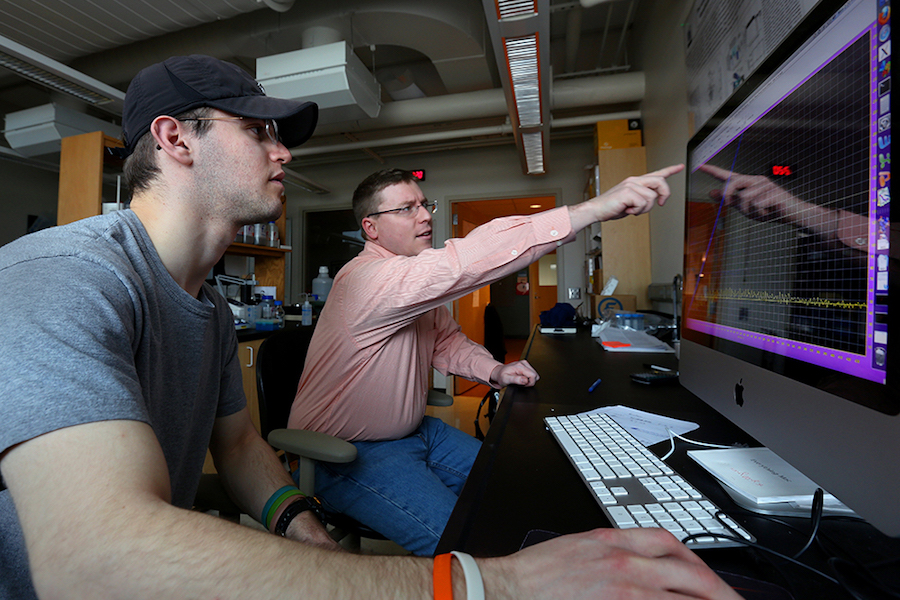 Two people work on a computer.