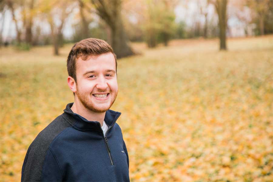 A person stands outside and smiles at the camera.