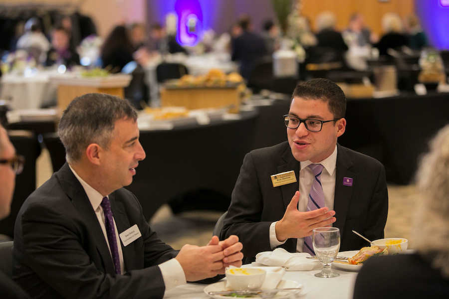 Brian Martinez talks with a state representative at a dinner.