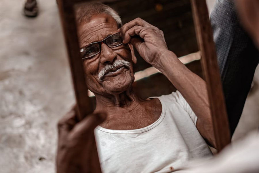 Photo of Enactus story and man looking at himself on mirror.
