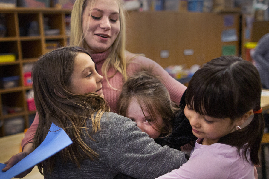 Hollyn Peterson hugs young students.