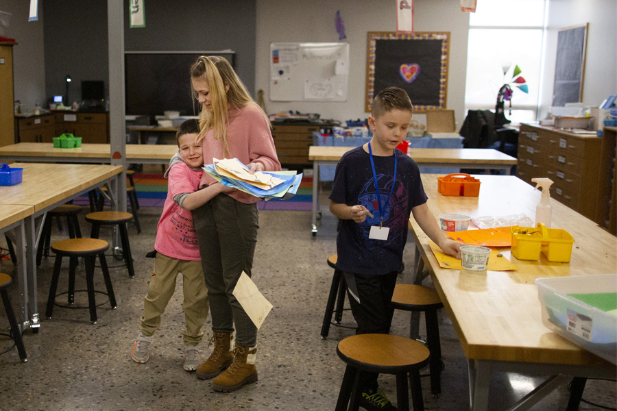 Hollyn Peterson hugs her students in the classroom.