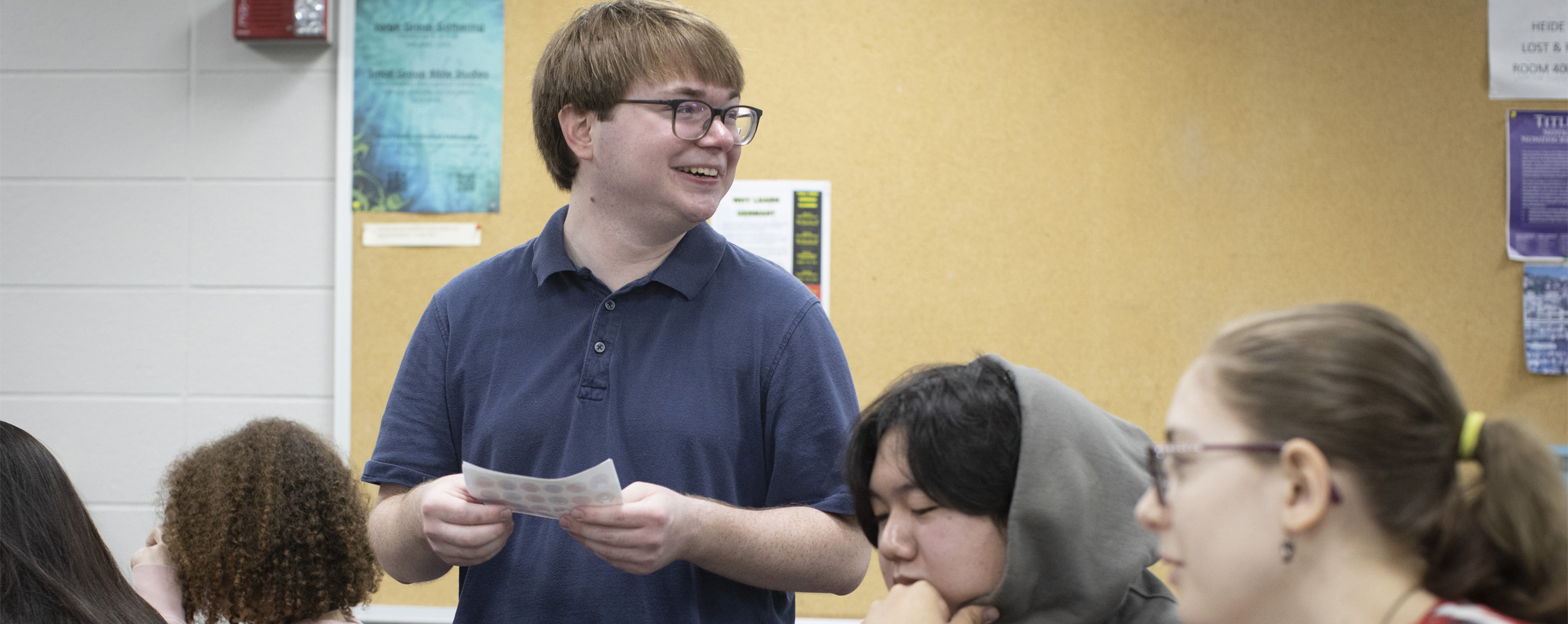 Nicholas Swiatowy stands in a classroom, smiling.