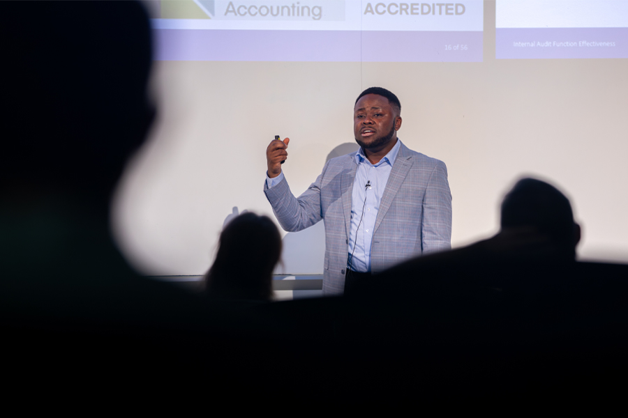 Patrice Achu defends his dissertation in front of a crowd.