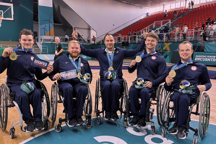 Five Warhawk wheelchair basketball athletes lined up showing their gold medals.