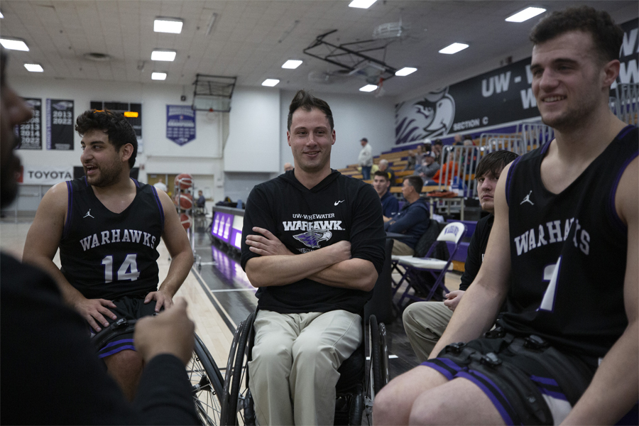 Three Warhawk wheelchair basketball athletes in the gym.