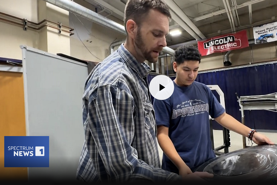 man helping student with a shield