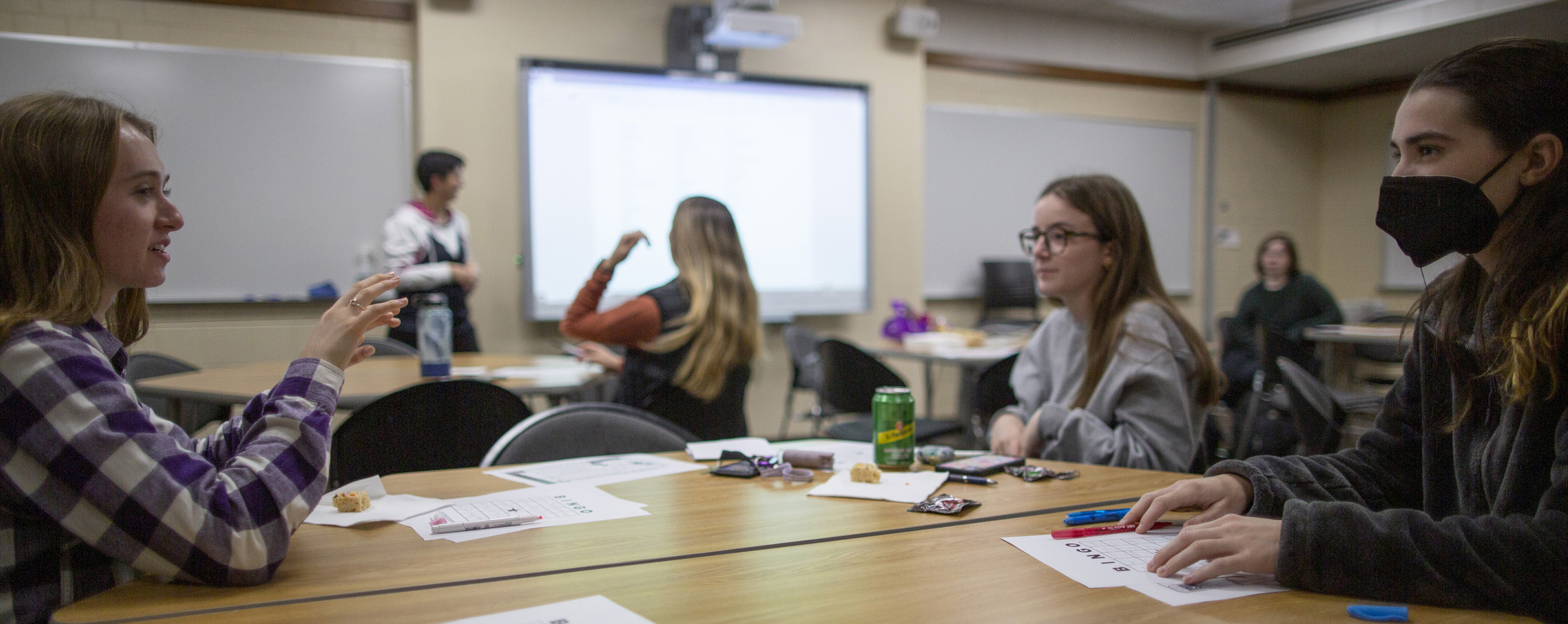 Students work together around a table in a classroom.