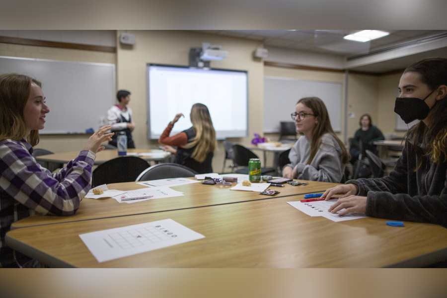 Students work together around a table in a classroom.