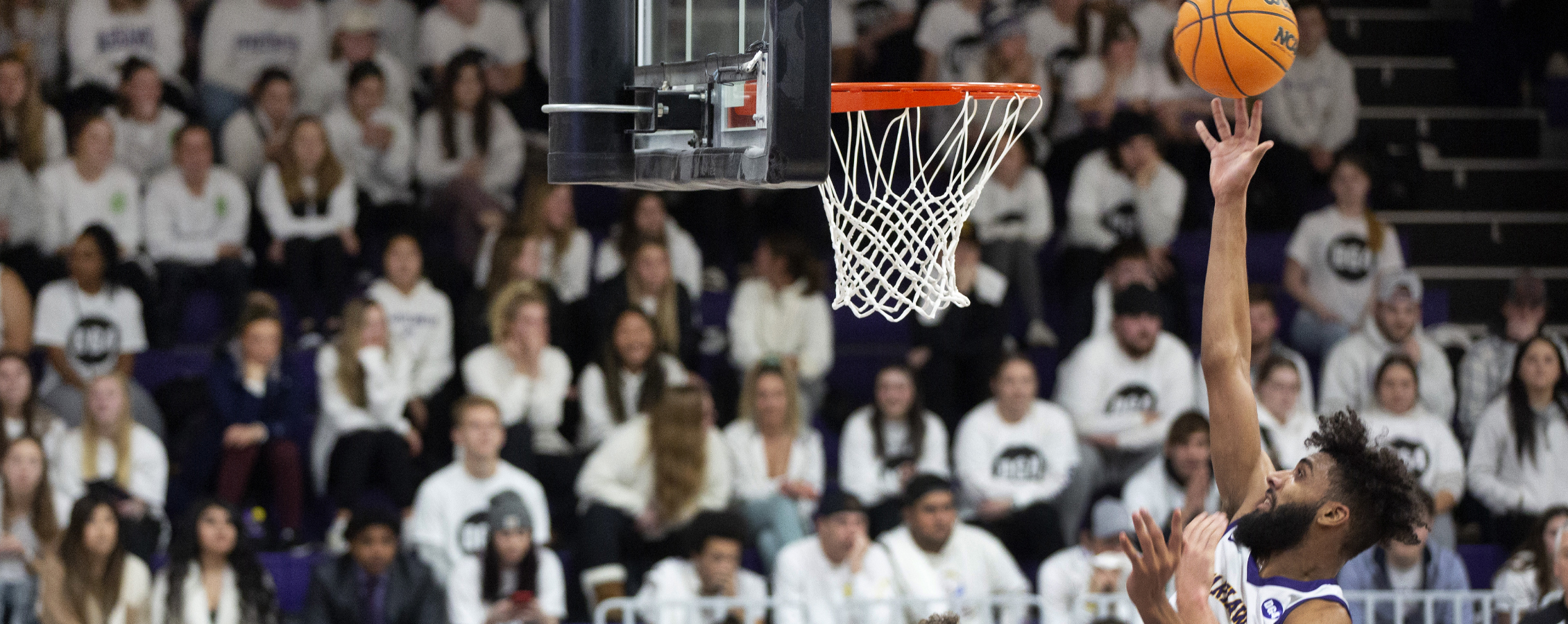 Tre Chislom jumps above a defender and shoots under the basket. 