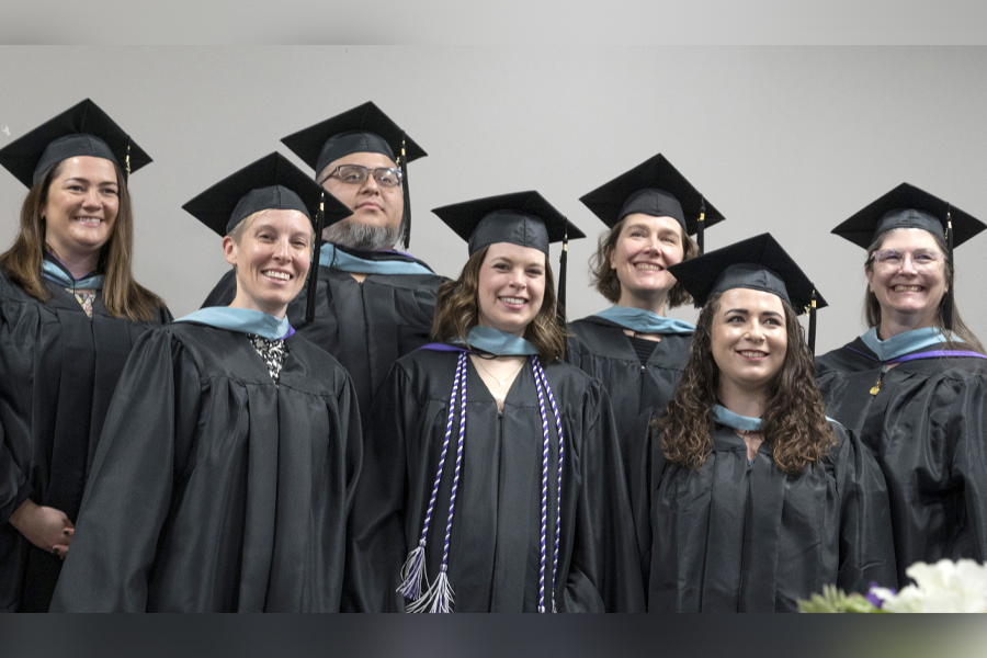 A group of students pose together in their academic regalia.