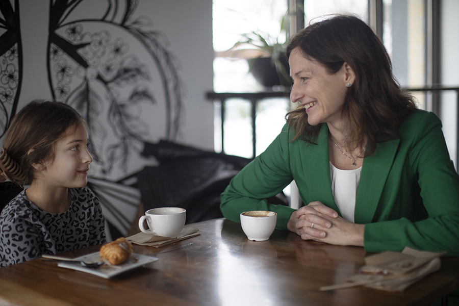 A mother and daughter sit together at a table.