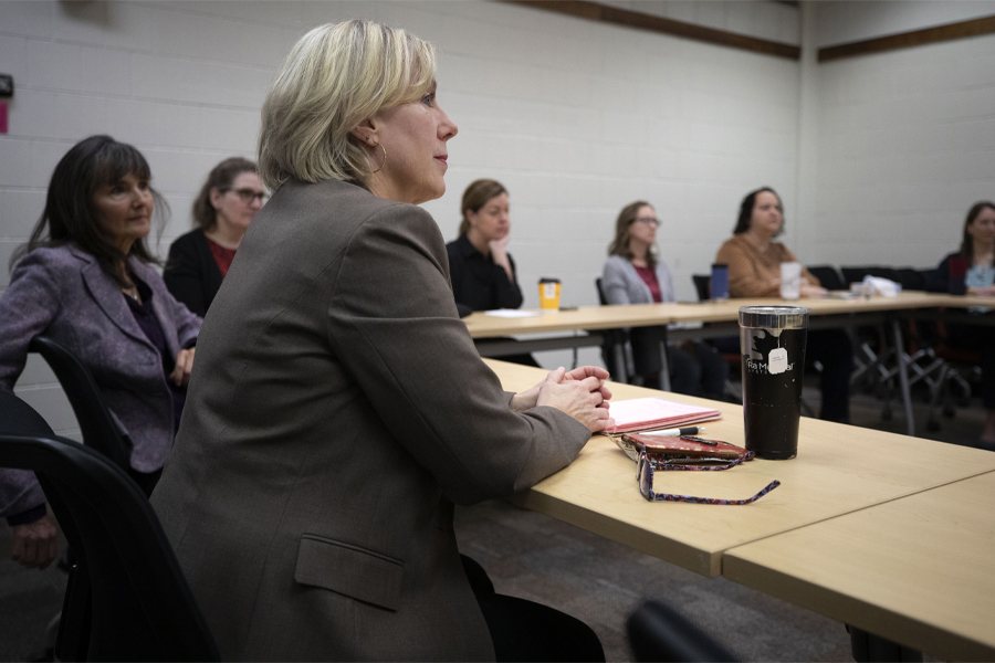 A person sits a table in a meeting.