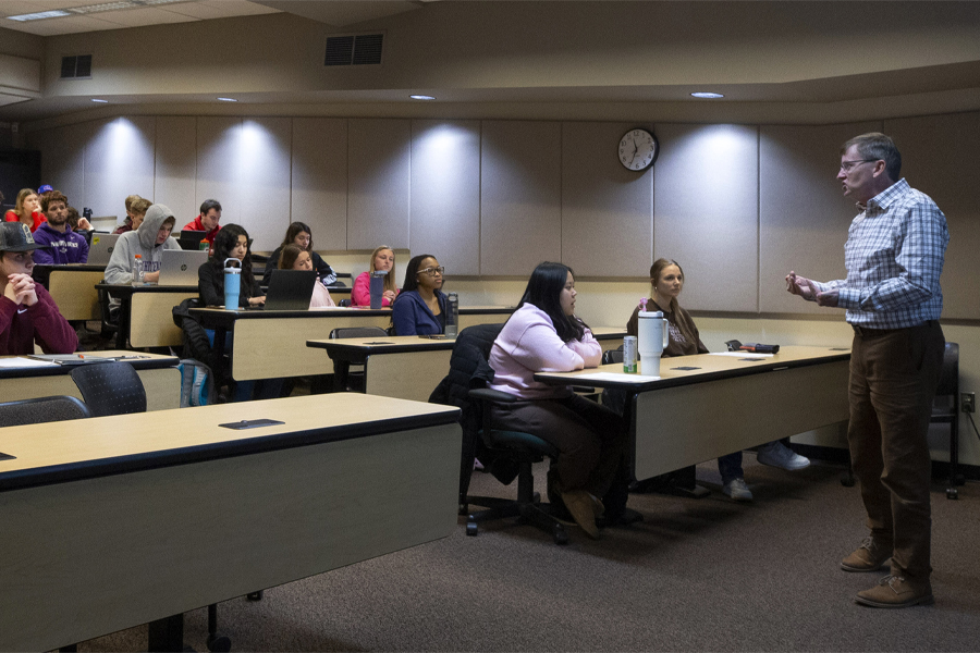 A faculty member teaches at the front of a special education class.