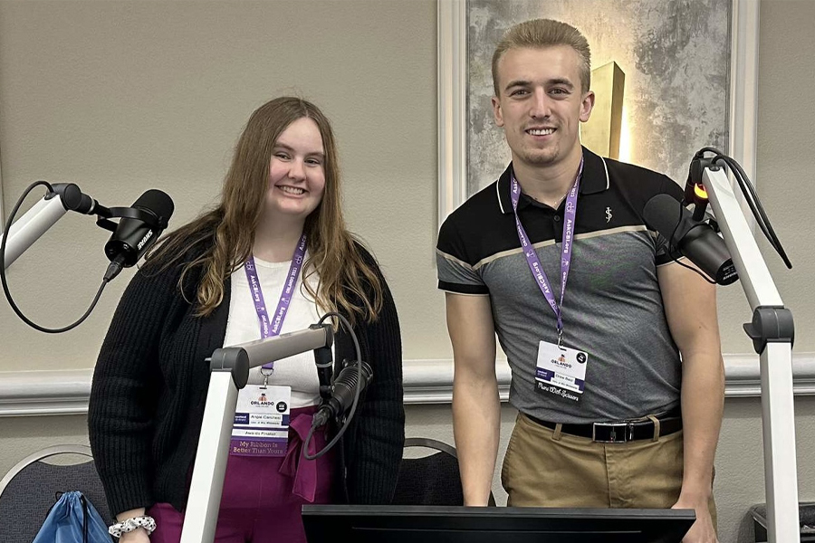 Drew Best stands with another student and they smile at the camera.