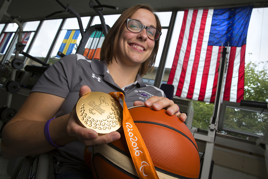 Christina Schwab smiles and shoes her gold medal to the camera.