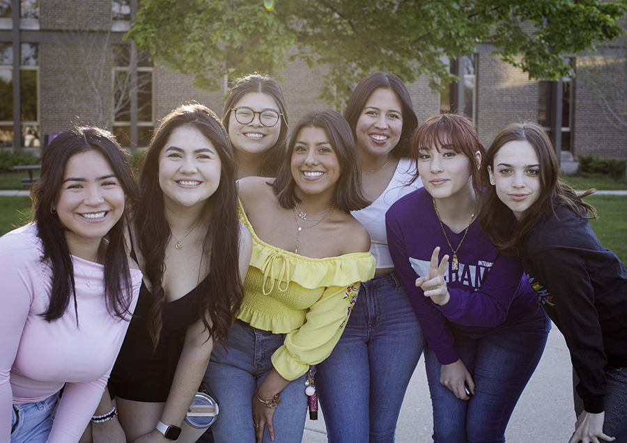 Seven people stand together and pose for a photo.