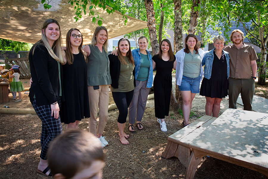 A group of Children's Center staff members stand together for a photo outside.