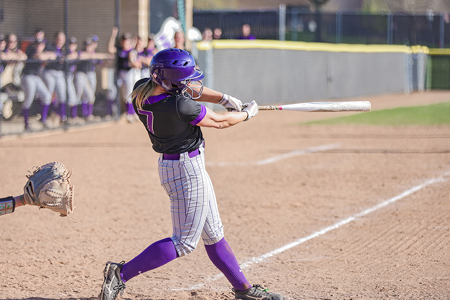 A Warhawk softball player swings at a pitch.