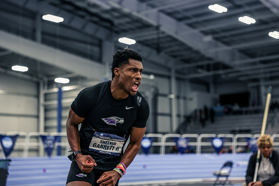 Shelvin Garett, wearing a Warhawk tshirt, pumps his arms in excitement in the fieldhouse.