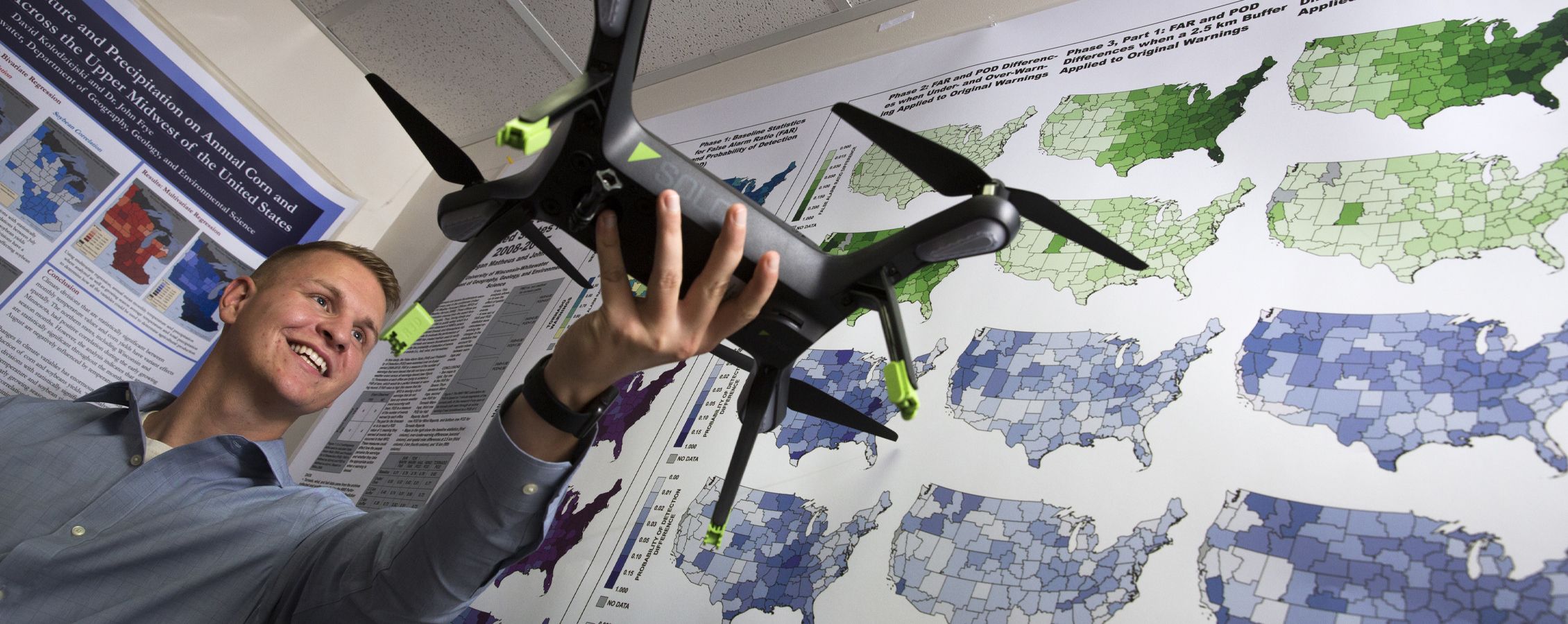 A person holds up a drone in the GIS lab.