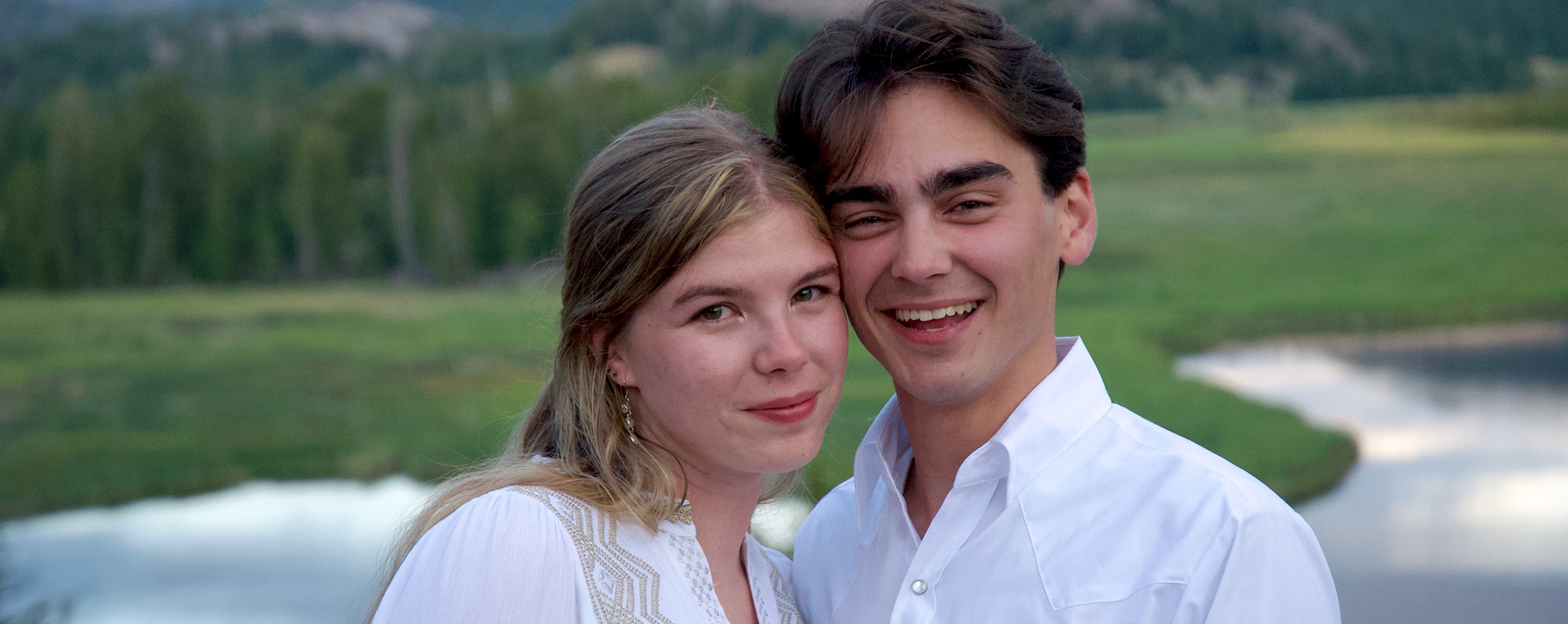 Two people stand together outside at a national park.