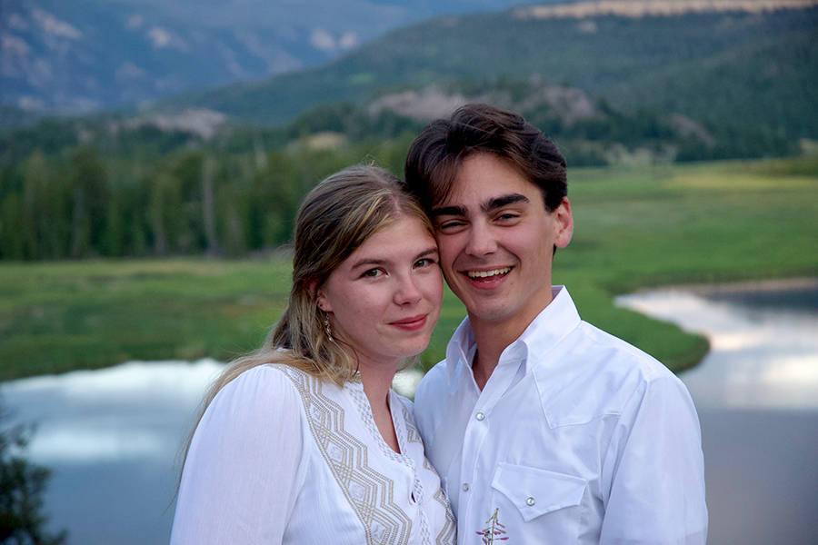 Two people stand together outside at a national park.