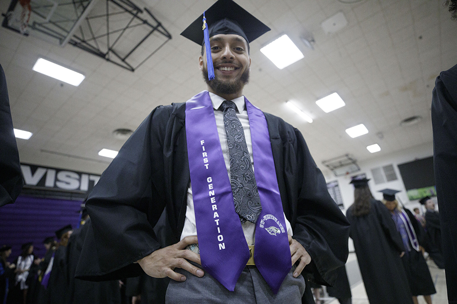 Brayden Jones smiles at graduation wearing a cap and gown.