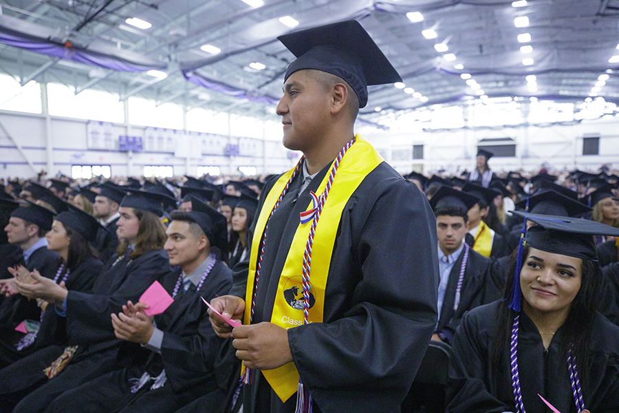 A military student stands during commencement as they are recognized.