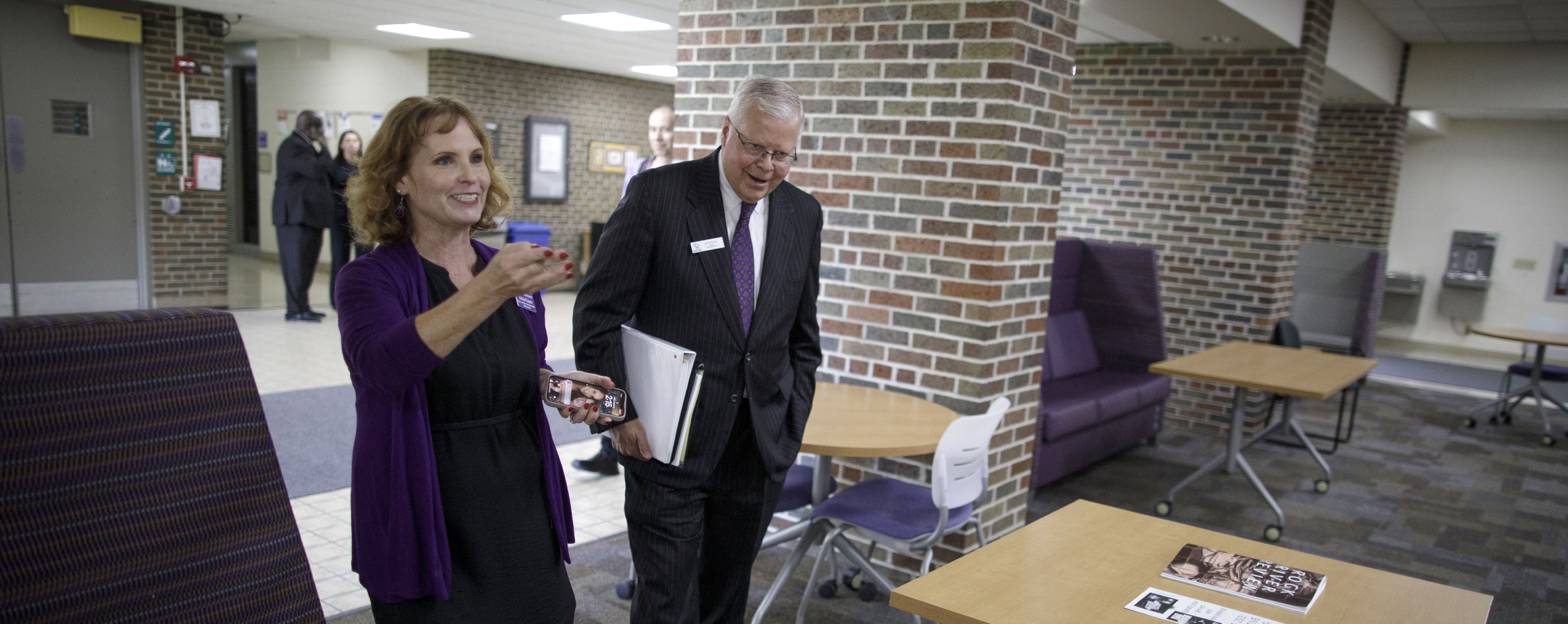 Dean Clasen points and smiles as she walks President Rothman around campus.