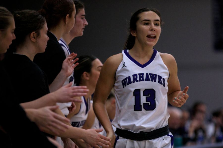 Kacie Carollo high fives other basketball players.