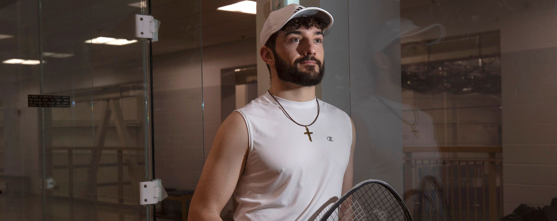 Photo of Joseph with racket on hand.