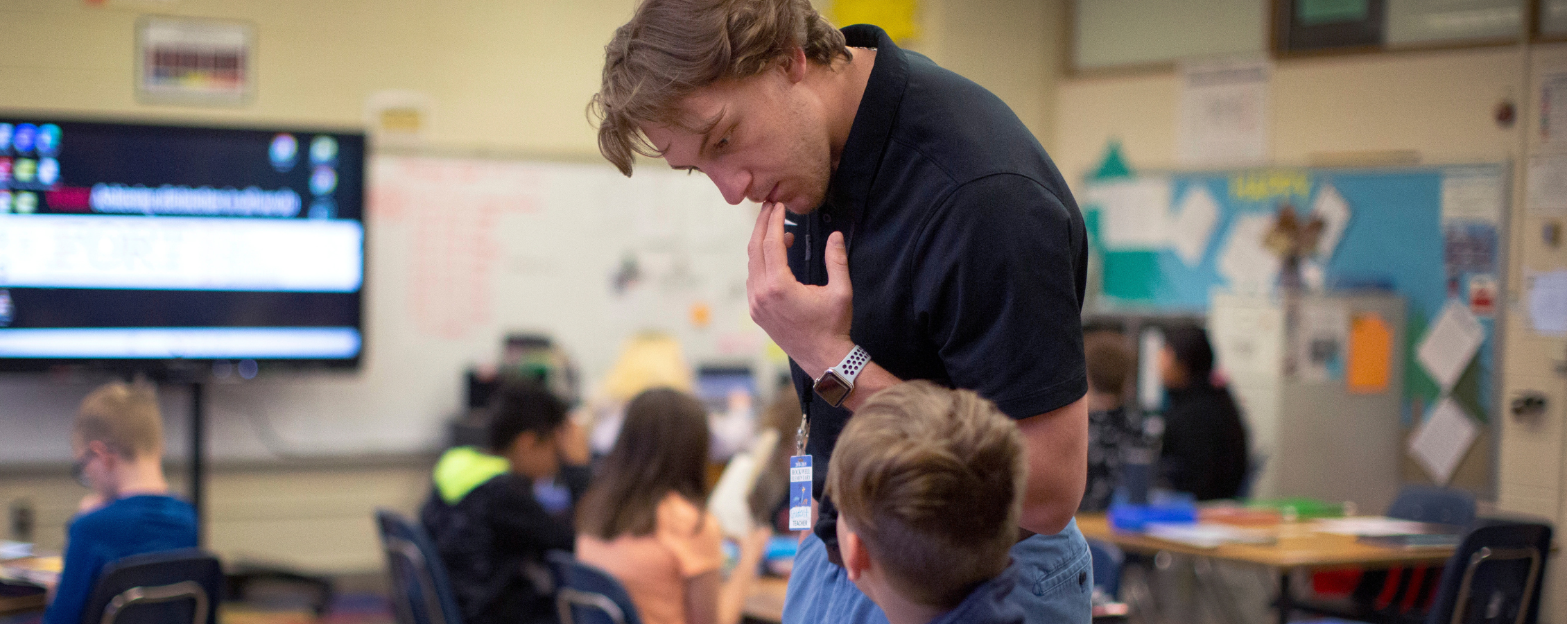 Student next to child in classroom.