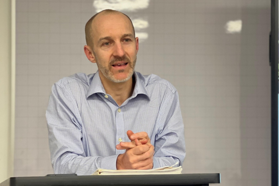 Photo of Andrew speaking at podium.