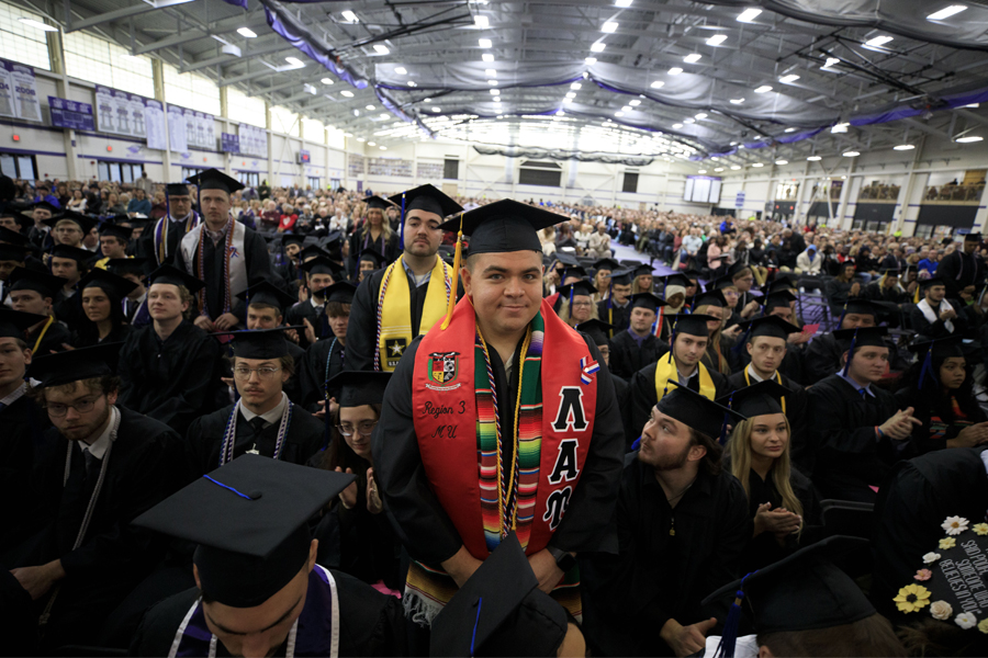 Group of students wearing caps and gowns at commencement ceremony.