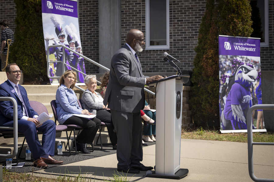 Chancellor Corey A. King stands at podium and welcomes the audience at the ceremonial groundbreaking on the Whitewater campus.